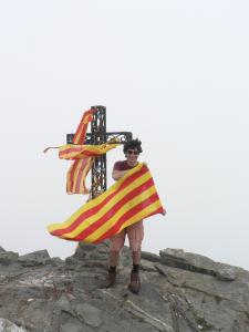 Foto d'un súbdit de la Turena brandant una bandera catalana al cim del Canigó